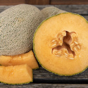 Netmelon 'Hale's Best Jumbo', Mørkegrønne, ovale frugter, dækket af et dekorativt, hvidt netmønster.